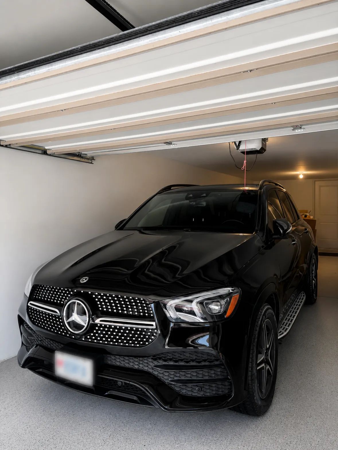 Black Mercedes GLE with a deep gloss finish after a full detail, photographed in a garage