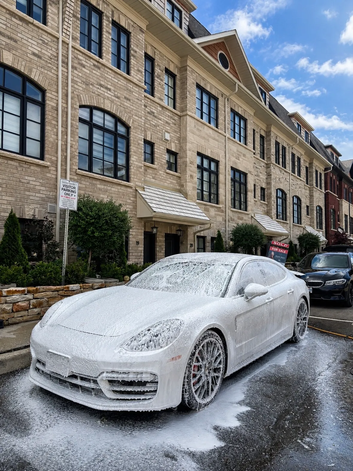 Porsche Panamera covered in thick snow foam during a driveway wash
